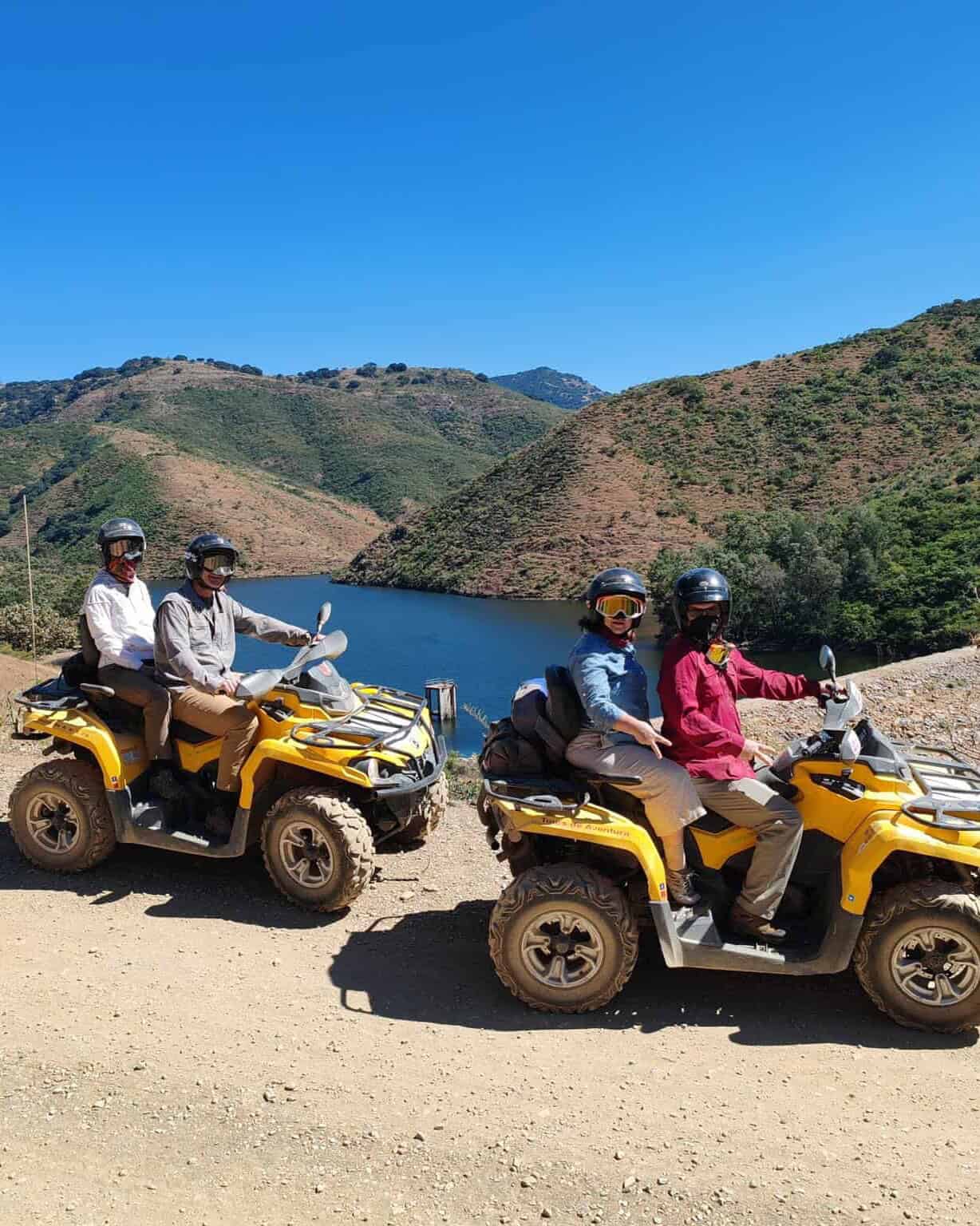 Dos parejas en cuatrimotos junto a una presa entre montañas en Guanajuato.