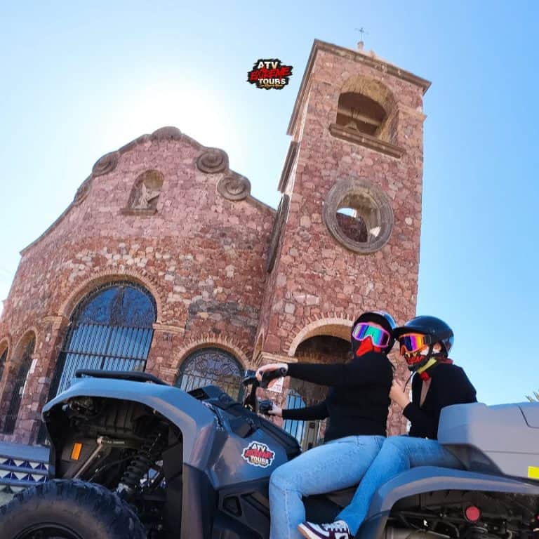 Viajeros en cuatrimoto frente a una iglesia, en un recorrido por los alrededores de San Miguel de Allende.