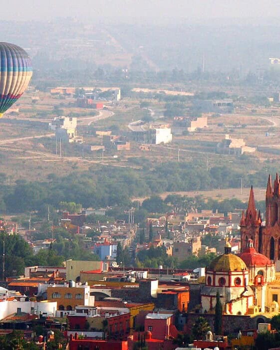 Globo aerostático sobrevolando San Miguel de Allende, con la Parroquia de San Miguel Arcángel en primer plano.
