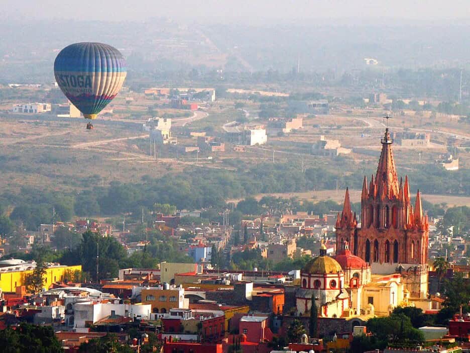 Globo aerostático sobrevolando San Miguel de Allende, con la Parroquia de San Miguel Arcángel en primer plano.