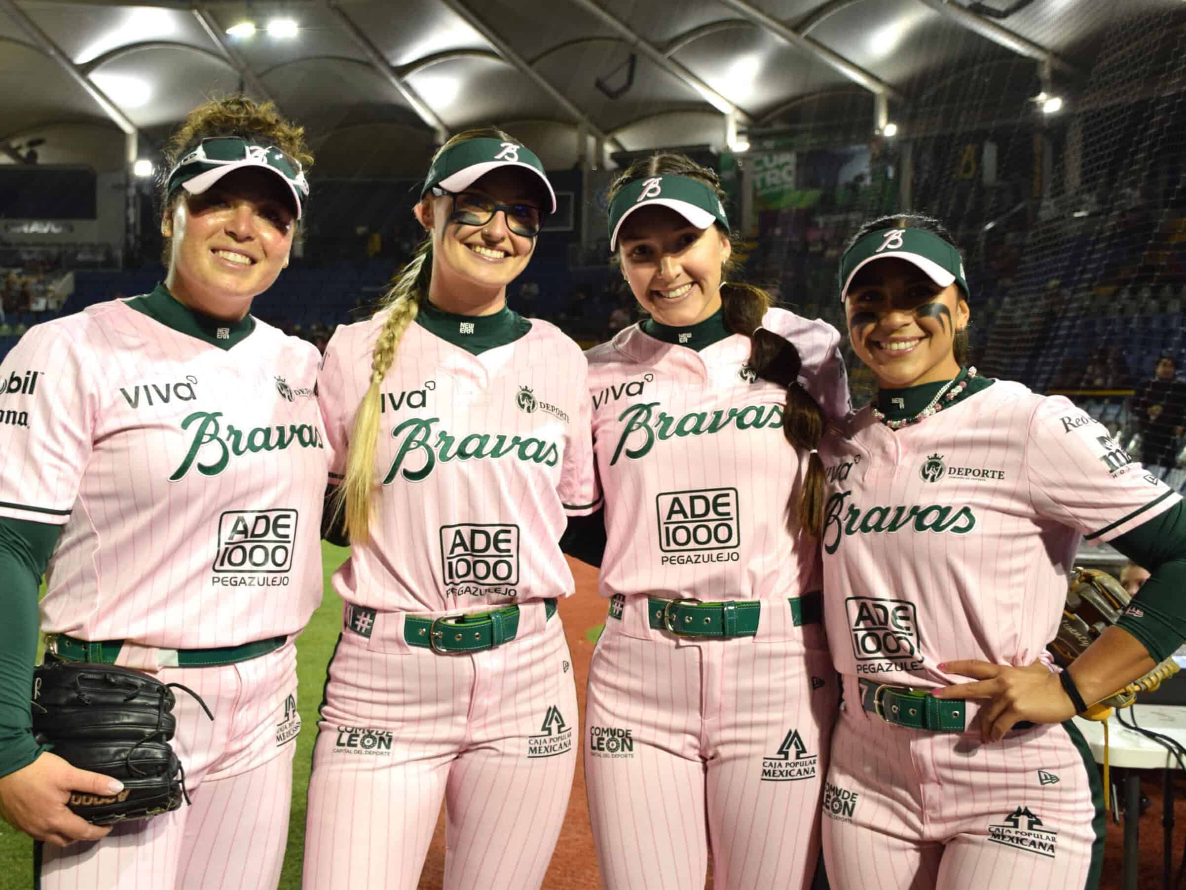 Equipo femenino de béisbol en Guanajuato luciendo uniformes rosas en evento deportivo.