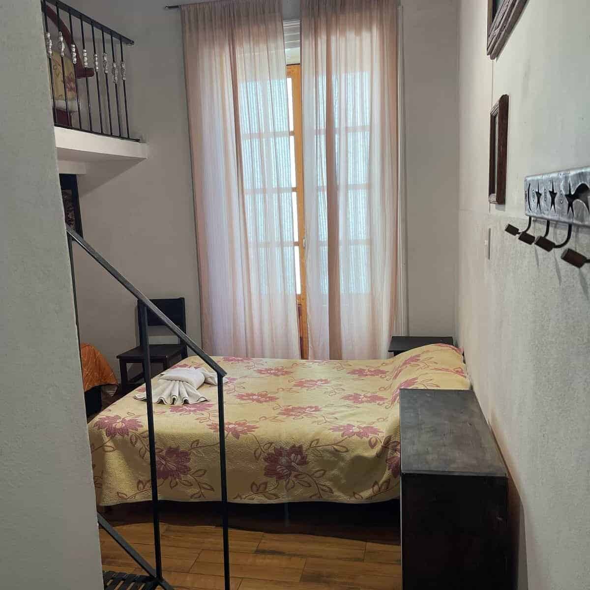Room in Guanajuato with a double bed, sheer curtains, and a bright atmosphere. Ideal for tourists.