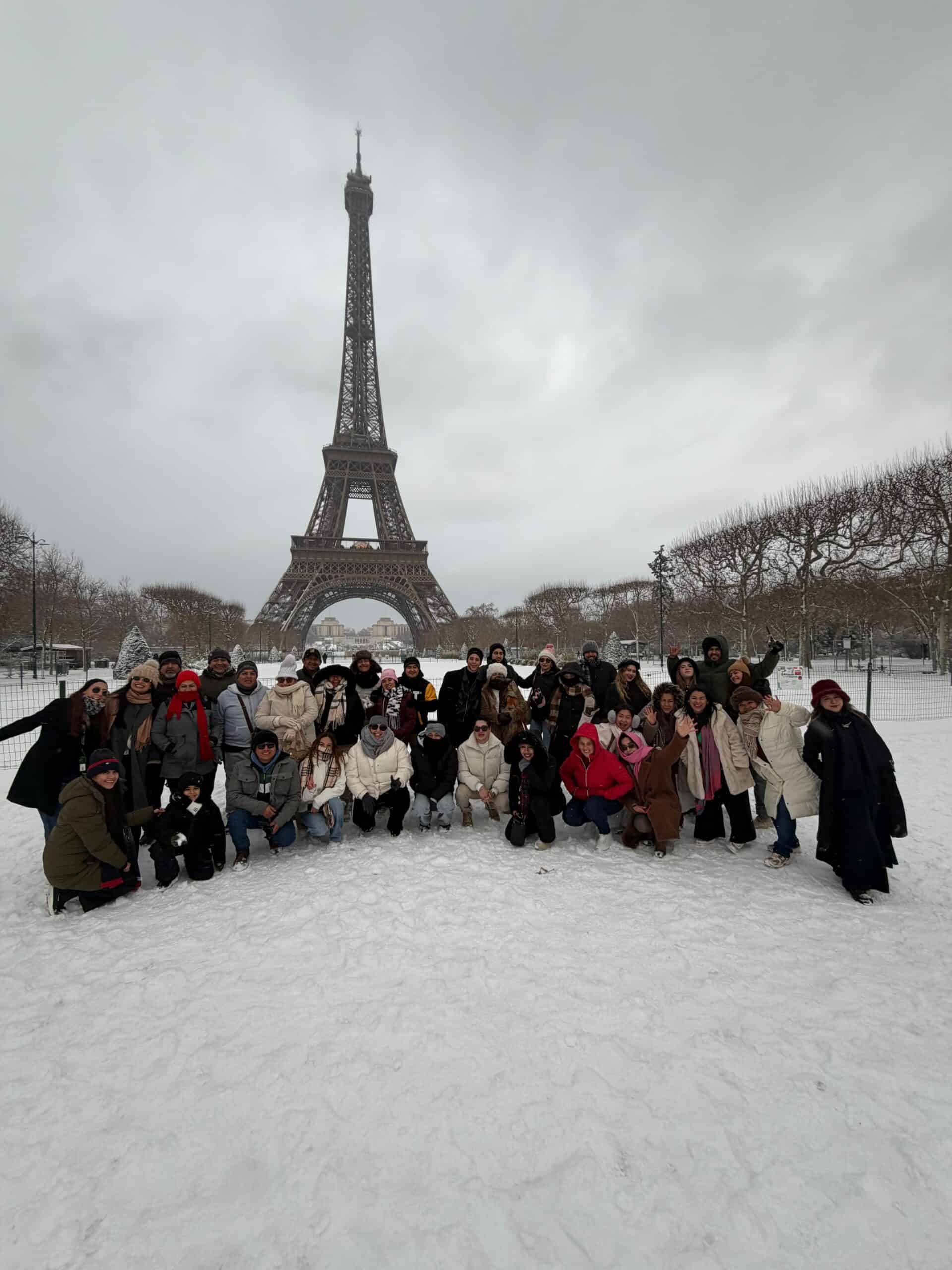 Grupo de turistas en Par&iacute;s con la Torre Eiffel de fondo en un d&iacute;a nevado.