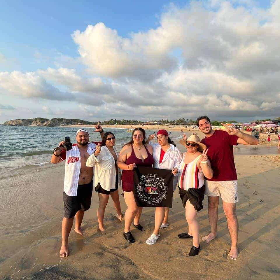 Grupo de turistas disfrutando en la playa de Guanajuato, México, con vistas al mar y actividades rec.