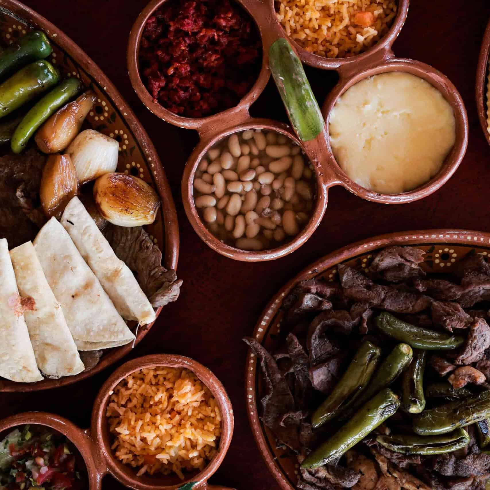 Comida mexicana tradicional con carnes, frijoles y salsas en Guanajuato.
