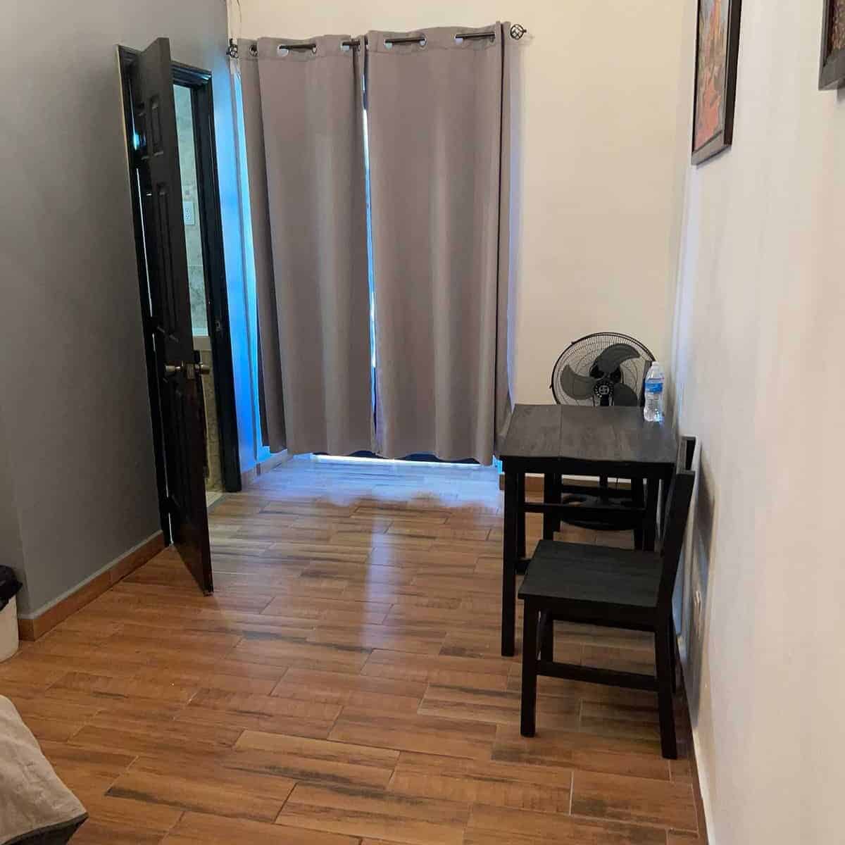 Room in Guanajuato with open doors and gray curtains.
