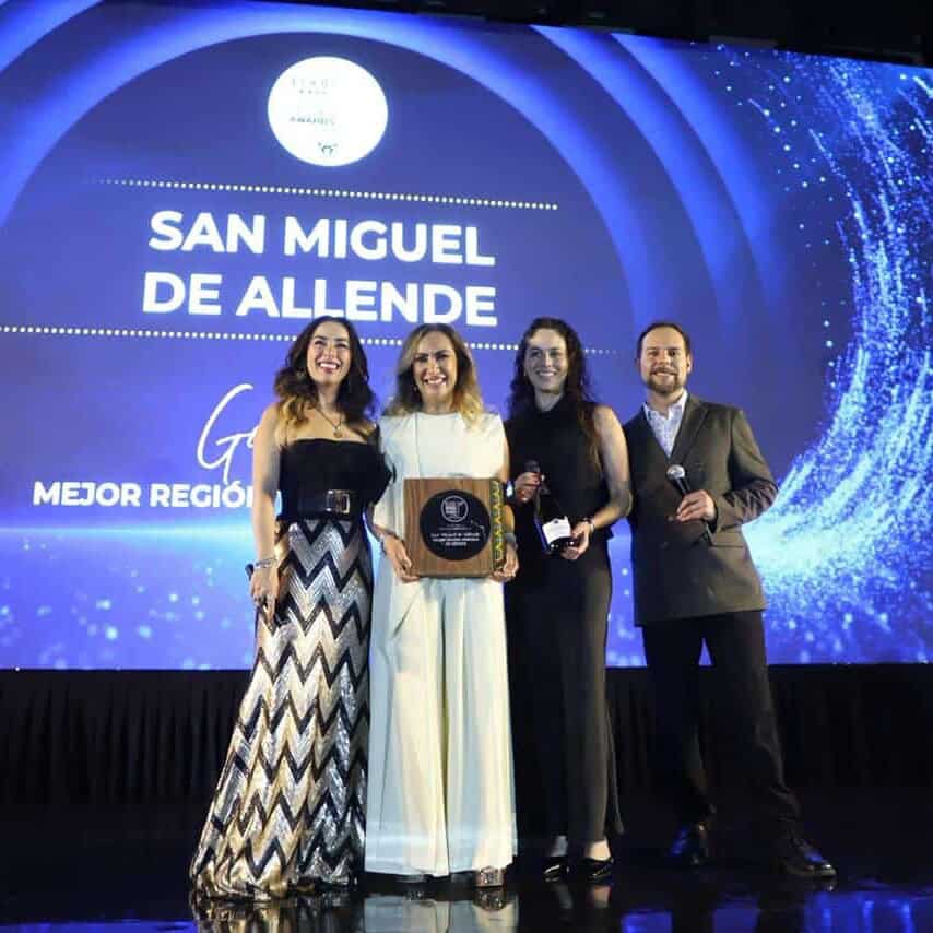 Four people on stage receiving an award at a tourism event in Guanajuato.