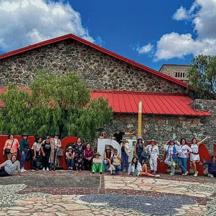 Grupo de turistas frente a una antigua estructura de piedra en Guanajuato, México.
