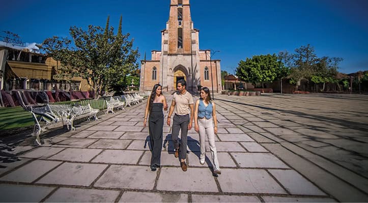 Jóvenes turistas caminando en la plaza principal de Guanajuato, México.