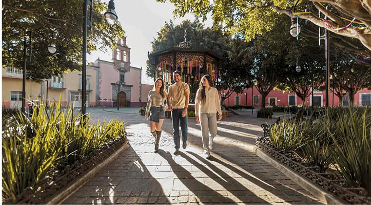 Turistas paseando en un parque de Guanajuato, México, en un día soleado.