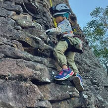 Niño escalando una pared de roca en una actividad de turismo de aventura en Guanajuato.