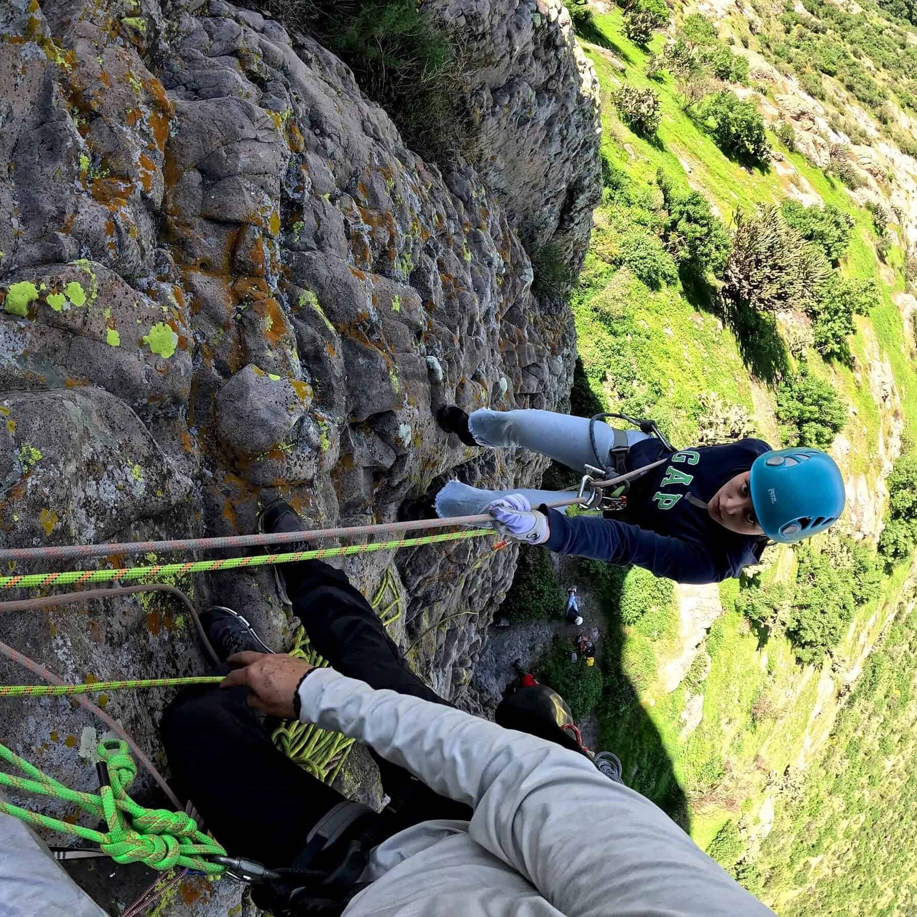 Persona escalando en una roca en un paisaje de montaña verde en Guanajuato.