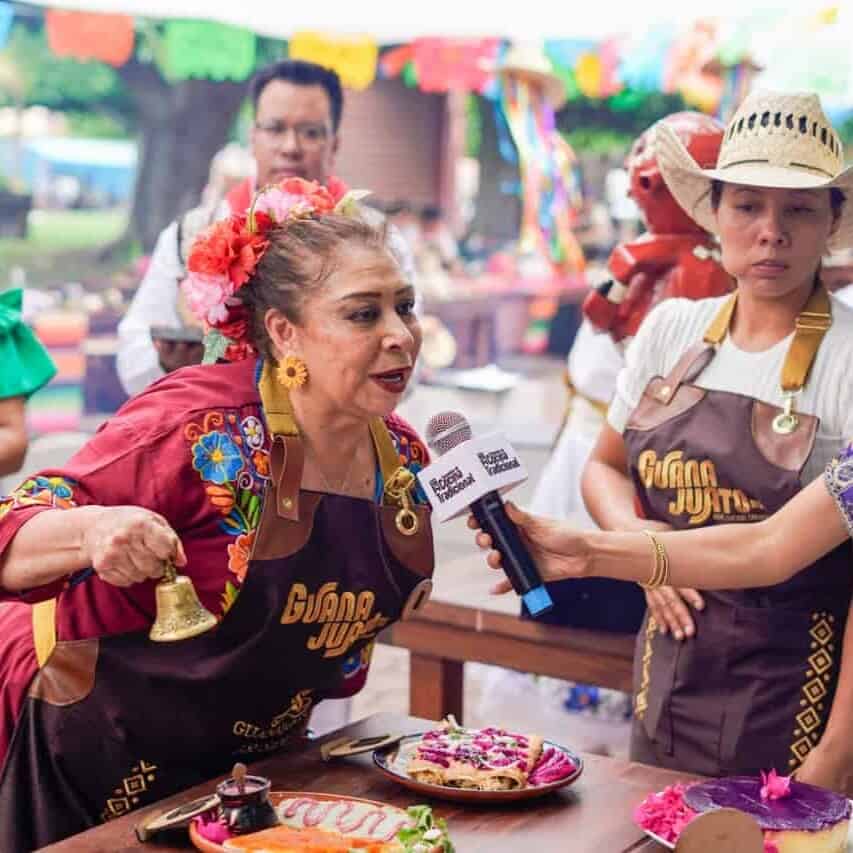 Mujer mayor en Guanajuato compartiendo tradiciones culinarias en festival local.