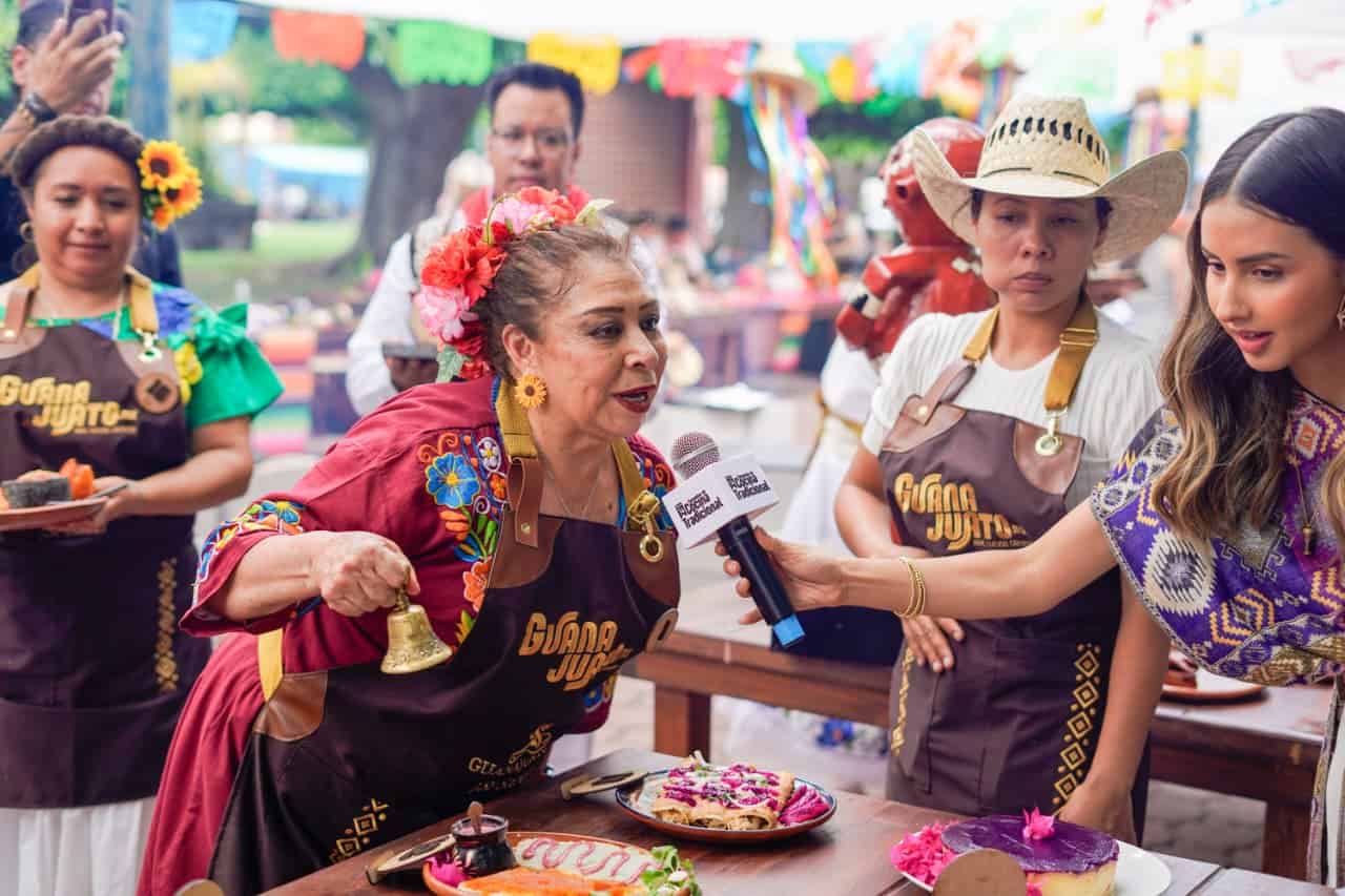 Mujer mayor en Guanajuato compartiendo tradiciones culinarias en festival local.