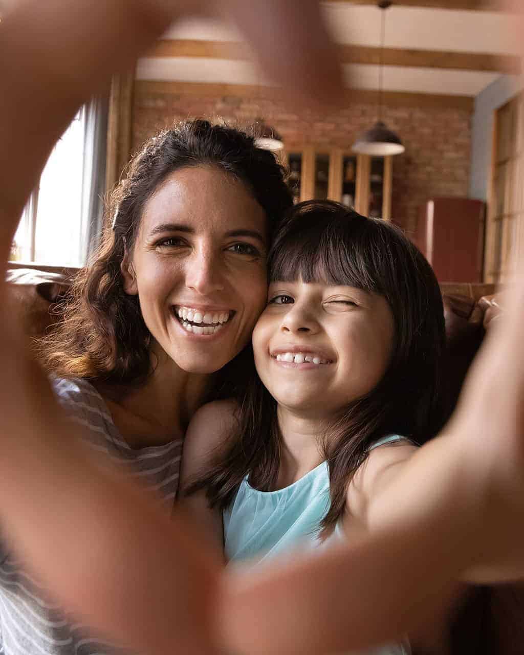 Woman and girl smiling, taking a selfie in Guanajuato, celebrating Mother's Day with joy.