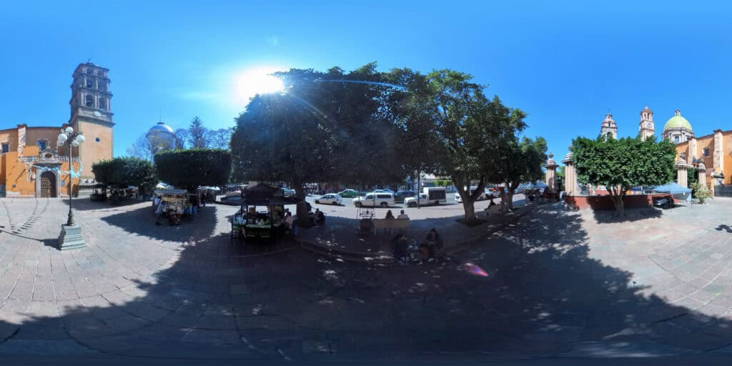 Vista 360° del jardín principal de Celaya, Guanajuato, rodeado de templos coloniales con torres y cúpulas.