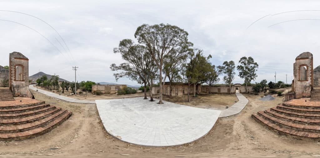 Vista 360° de las ruinas de una antigua hacienda minera en Mineral de Pozos, Guanajuato, con muros de piedra, gradas y eucaliptos.
