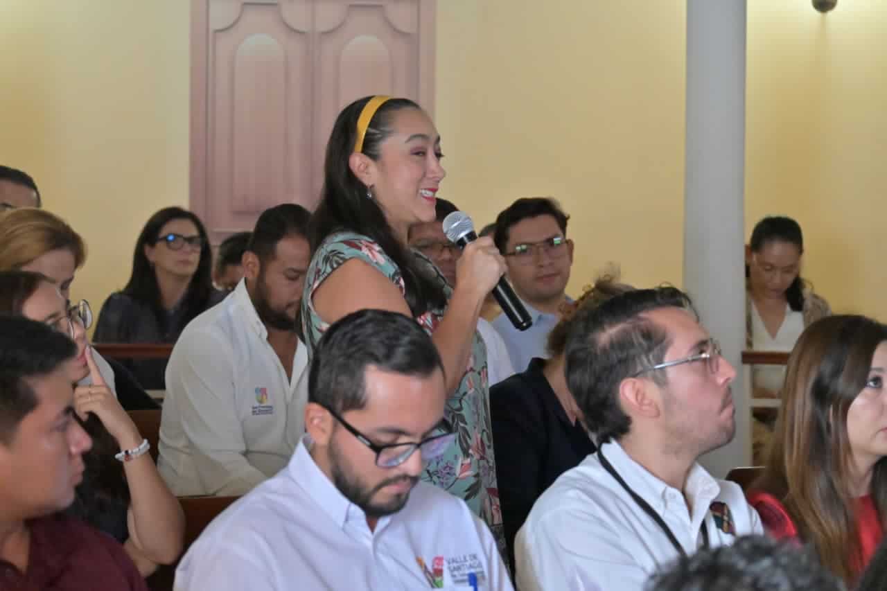 Mujer participando en evento cultural en Guanajuato, M&eacute;xico, con audiencia atenta.