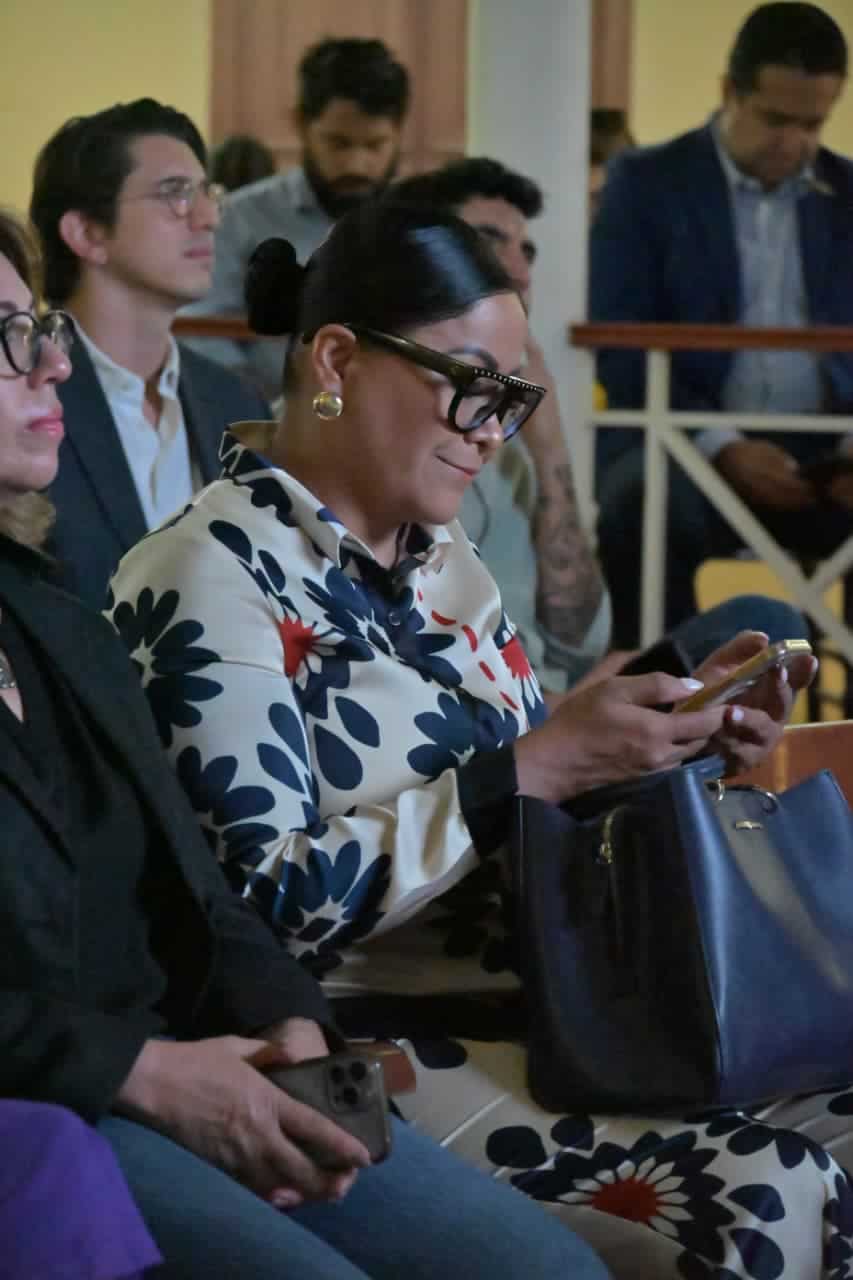 Mujer usando smartphone en evento tur&iacute;stico en Guanajuato, M&eacute;xico.