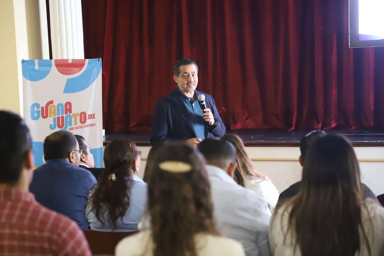 Conferencista hablando sobre turismo en Guanajuato frente a audiencia en un evento.