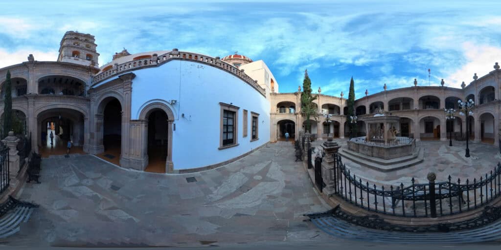 Vista 360° de un patio colonial en Salvatierra, Guanajuato, con fuente central, arcos de cantera y reja de hierro forjado.