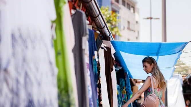 Joven comprando ropa en mercado de Moroleón, Guanajuato, México.