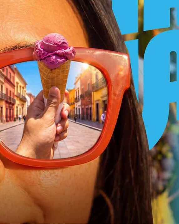 Mujer con gafas de sol reflejando calles de Guanajuato en verano.