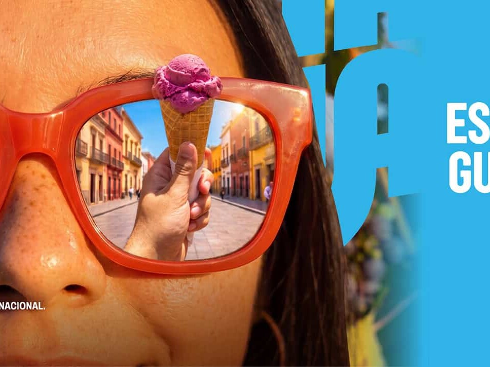 Mujer con gafas de sol reflejando calles de Guanajuato en verano.