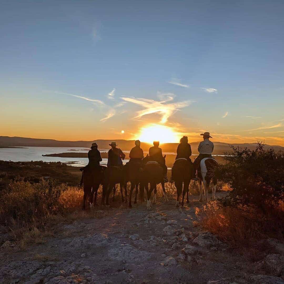Grupo de personas montando caballos al atardecer en Guanajuato.