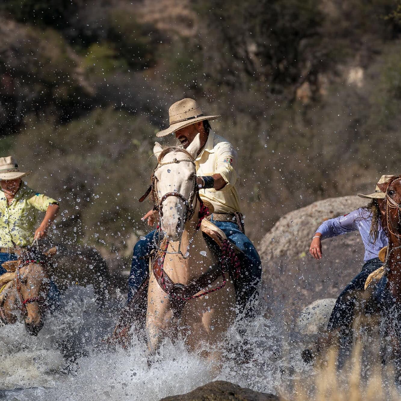Turistas montando caballos en un río en Guanajuato, México.