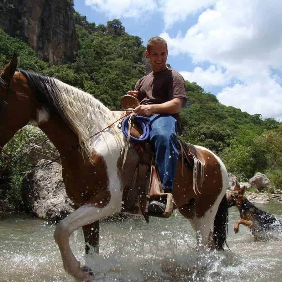 Turista montando caballo en río en Guanajuato, México, aventura y naturaleza.