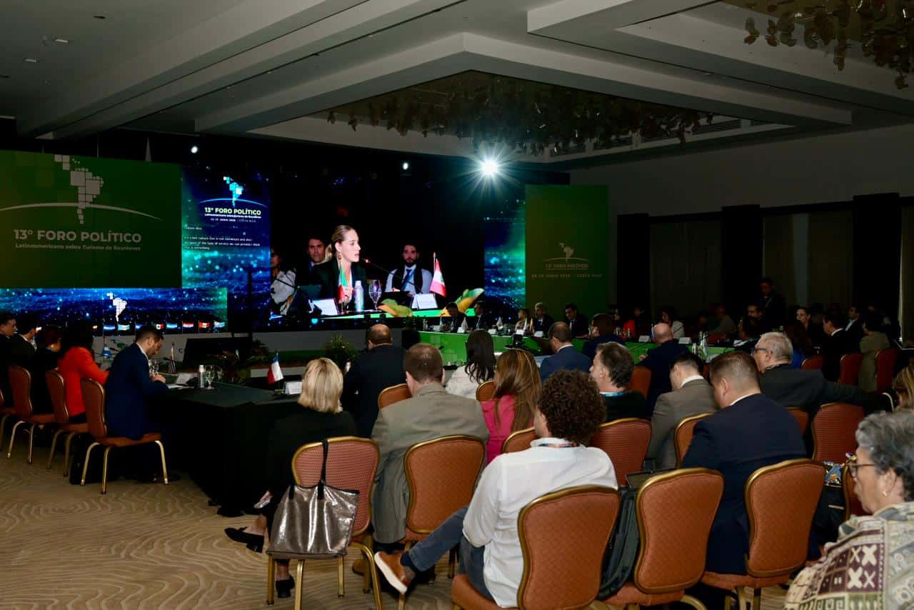 El evento político en un salón de conferencias con audiencia atenta y pantallas grandes mostrando la.
