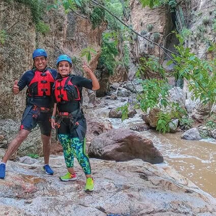 Aventureros en kayak en un cañón de Guanajuato con vegetación y agua marrón.