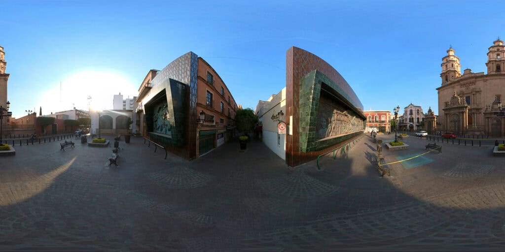 Vista 360° de la plaza junto a la Catedral Basílica de León, Guanajuato, con muros de mosaico y edificios históricos.
