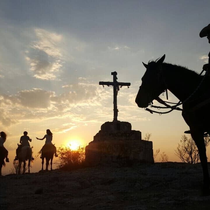Caballeros montando caballos al atardecer en Coyote Canyon, Guanajuato.