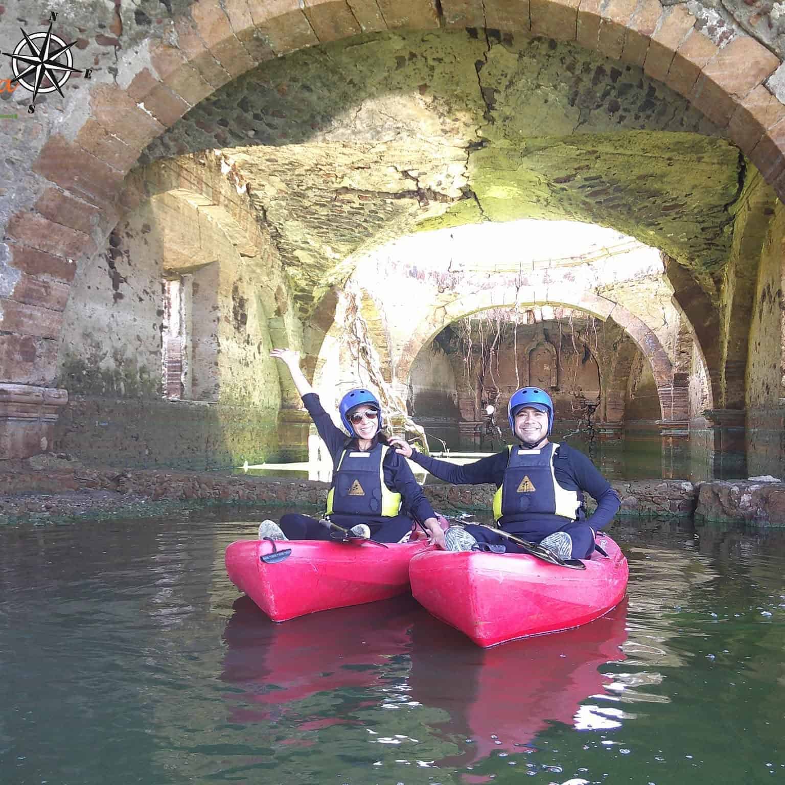 Dos personas en kayak en un río bajo un puente antiguo en Guanajuato, México.
