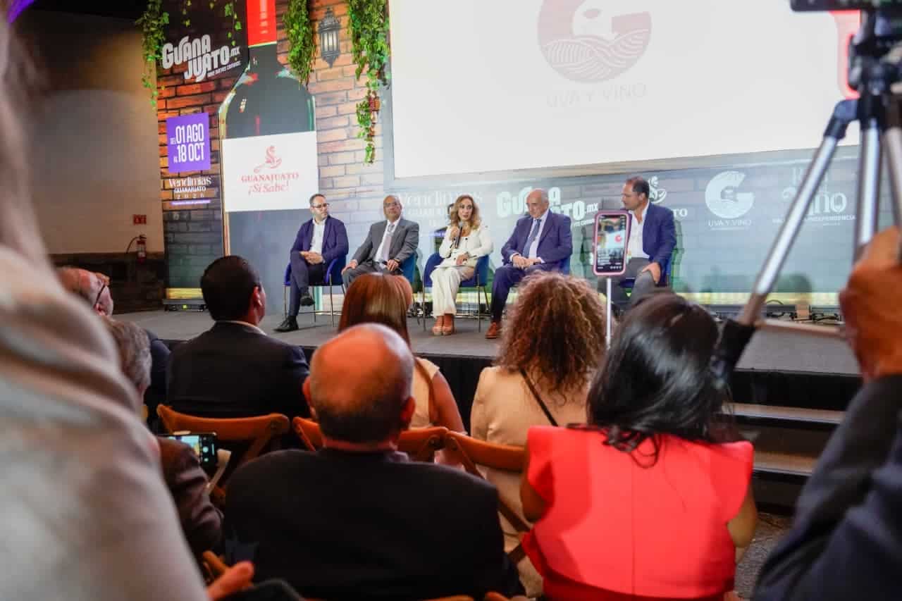 Evento de turismo en Guanajuato con panelistas y audiencia en un escenario moderno.