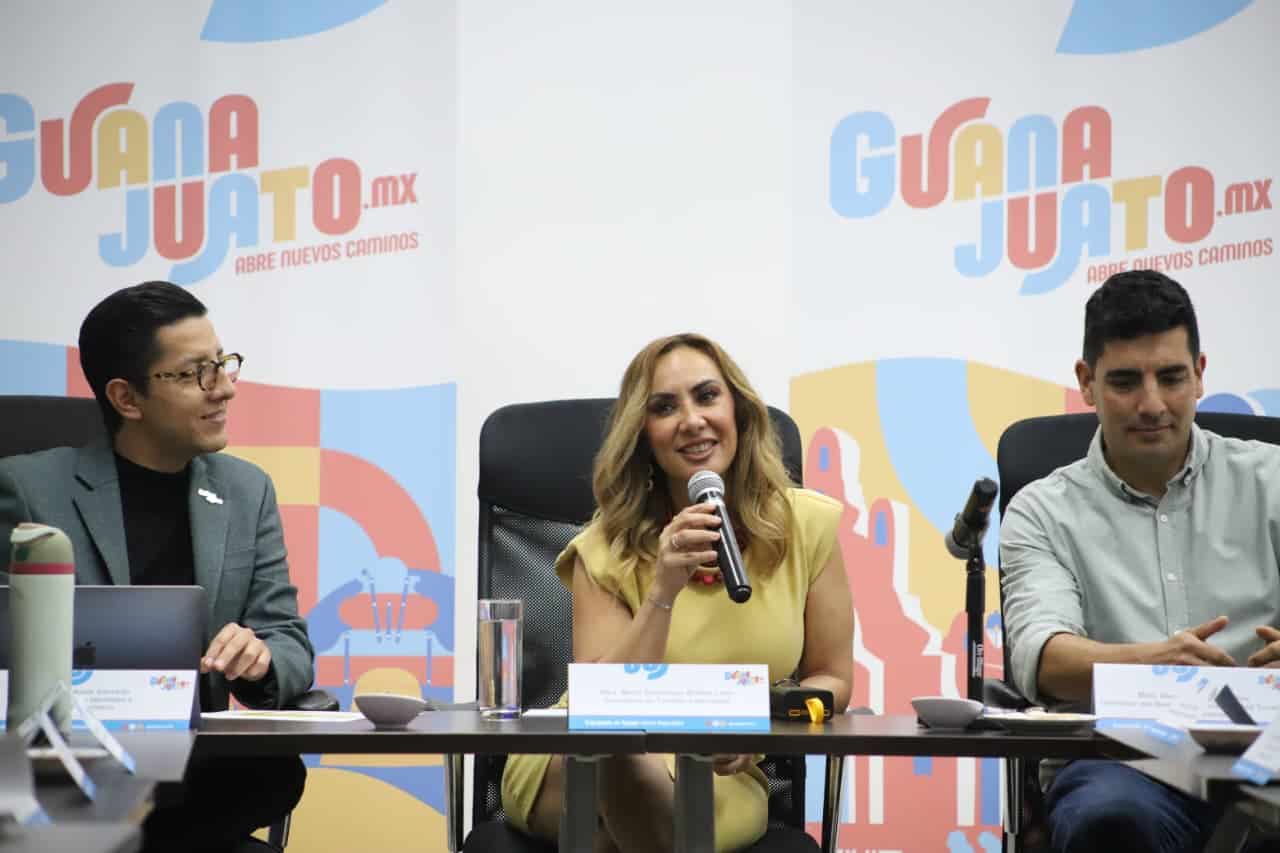 Tres personas en mesa durante evento de turismo en Guanajuato.