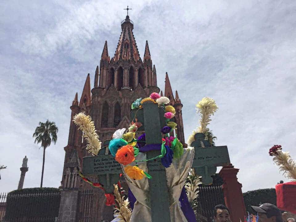 Fachada de la iglesia en San Miguel de Allende con ofrendas florales y decoraciones.