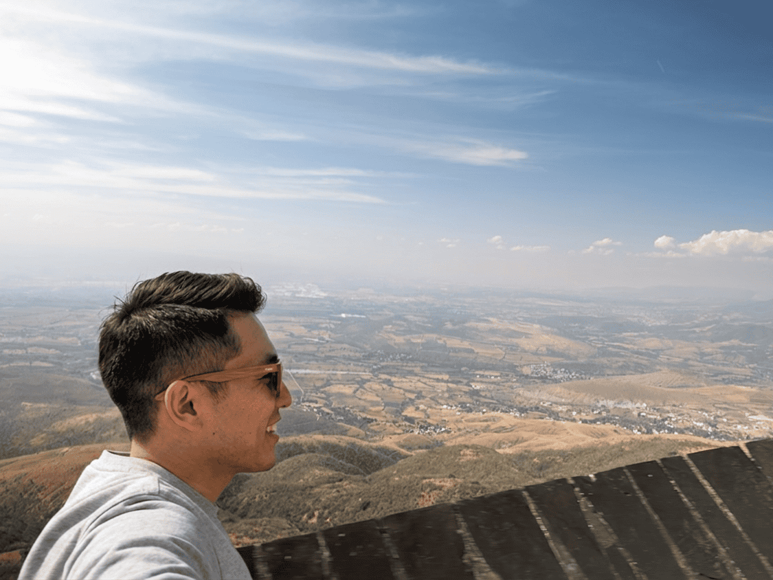 Joven disfrutando de la vista panorámica de Guanajuato desde una montaña.