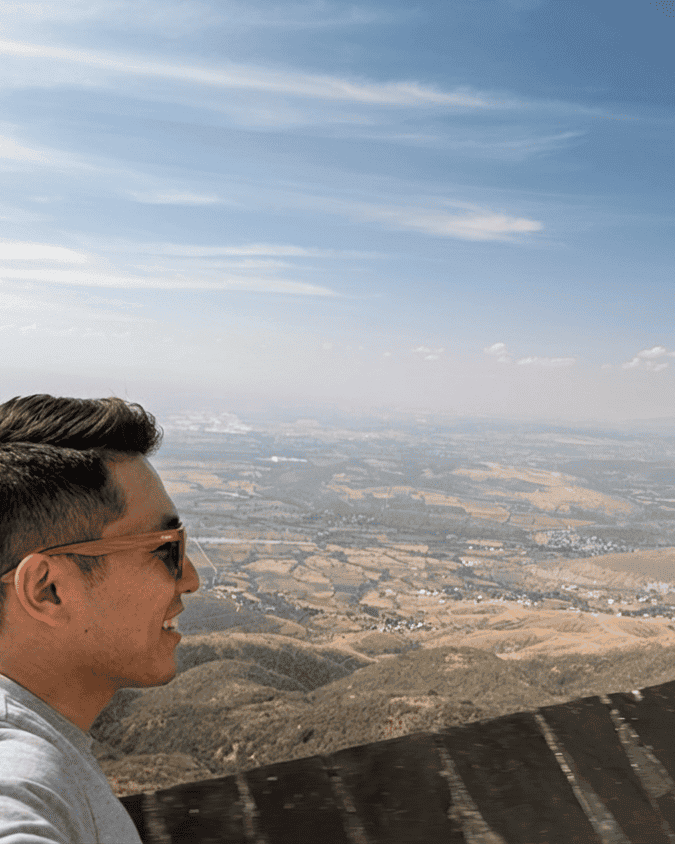 Young person enjoying the panoramic view of Guanajuato from a mountain.