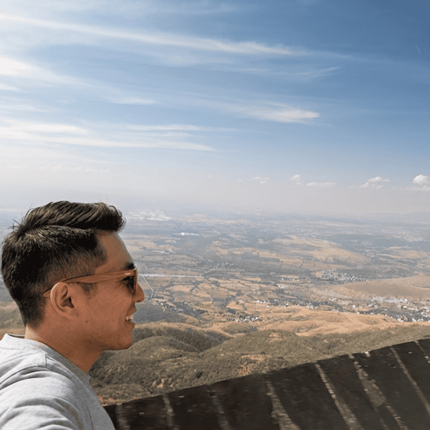 Joven disfrutando de la vista panor&aacute;mica de Guanajuato desde una monta&ntilde;a.