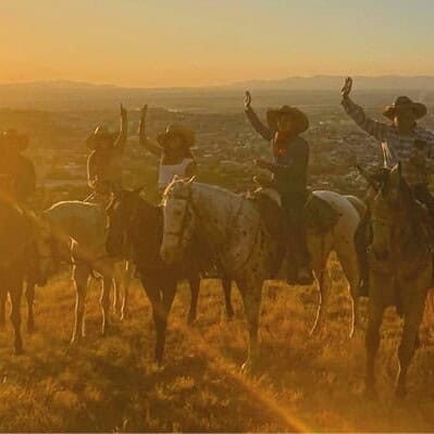 Grupo de personas montando caballos al atardecer en Guanajuato.