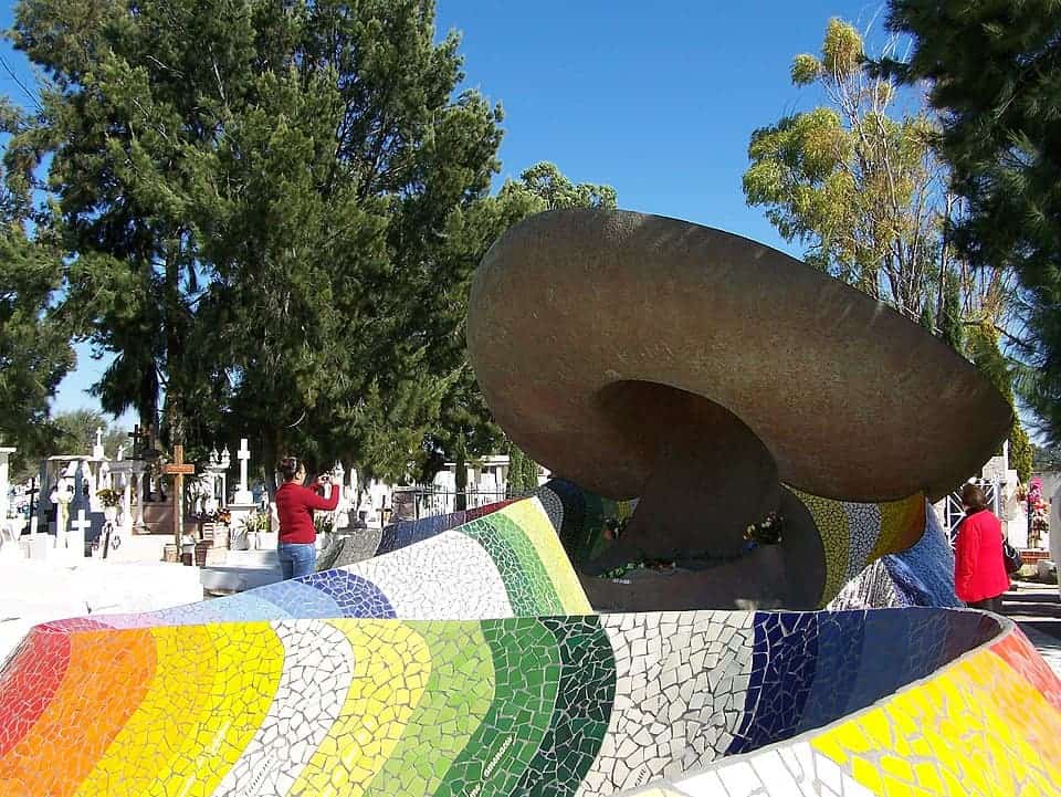 Escultura colorida en parque de Guanajuato con &aacute;rboles y cielo azul.