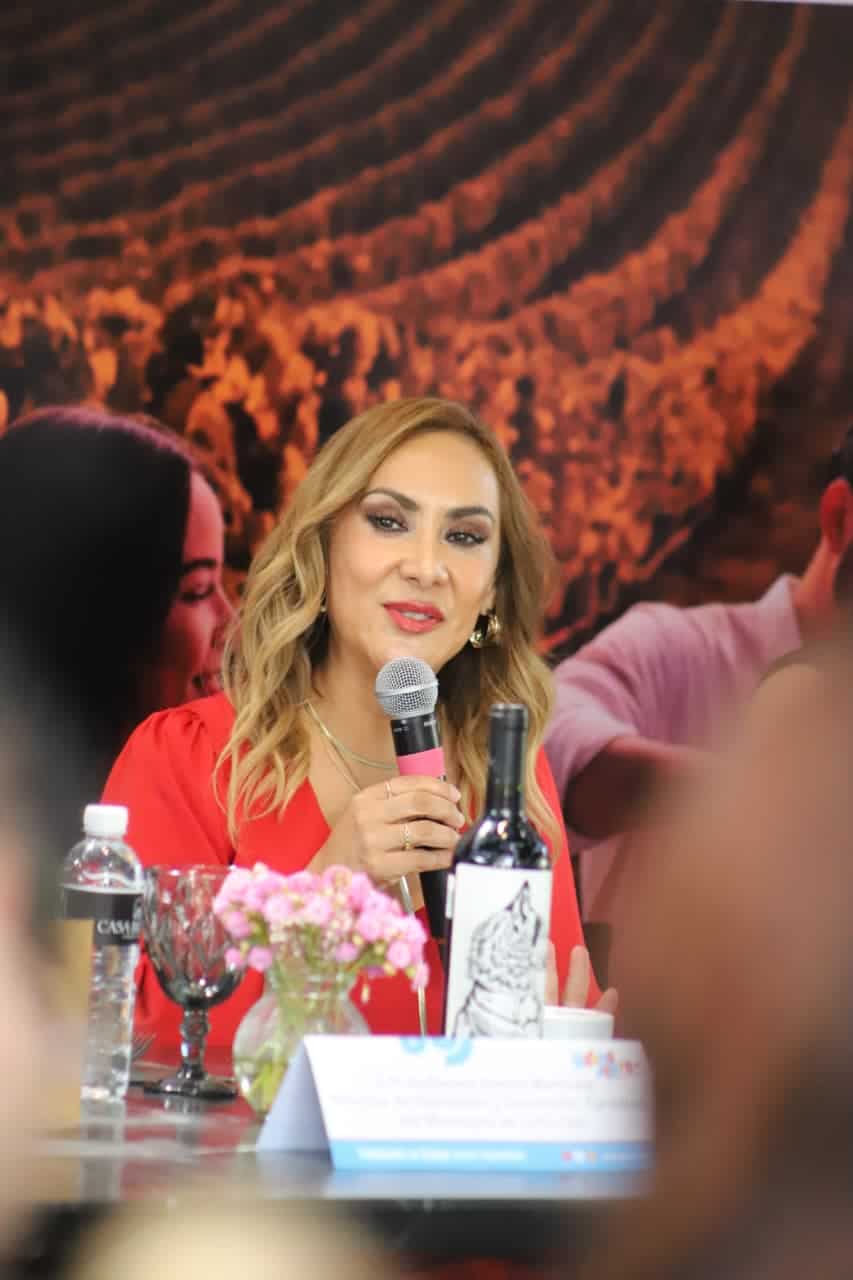 Mujer en evento de gastronom&iacute;a tradicional de Guanajuato con micr&oacute;fono en mano.