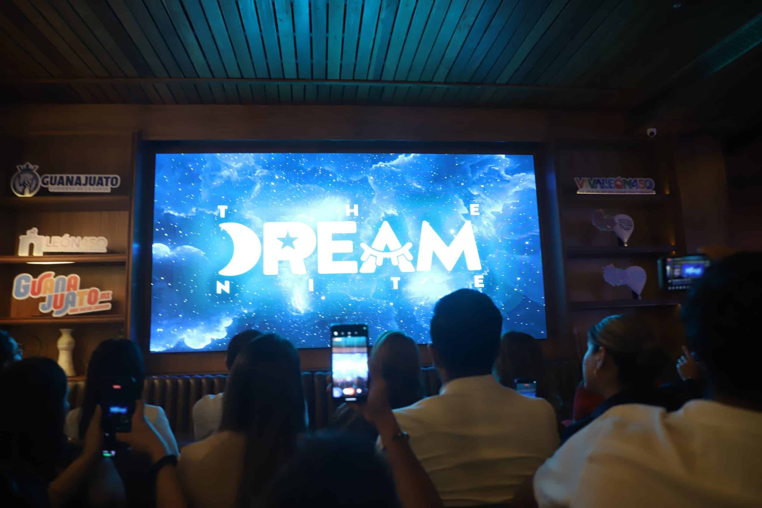 Personas viendo una pantalla con la palabra 'DREAM' en un evento en Guanajuato.
