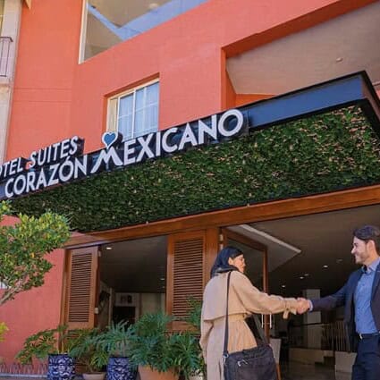 Entrada del Hotel Suites Corazón Mexicano en Guanajuato, con fachada moderna y vegetación.