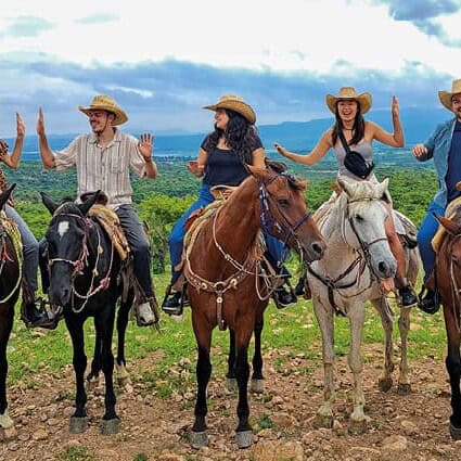 Turistas montando caballos en un paisaje de Guanajuato, México.