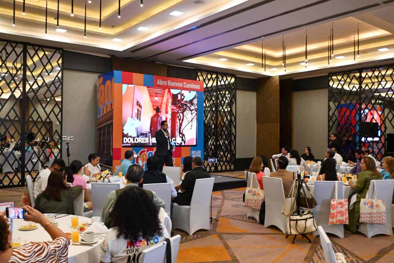 Evento de turismo en Guanajuato con presentaciones y asistentes en un sal&oacute;n elegante.