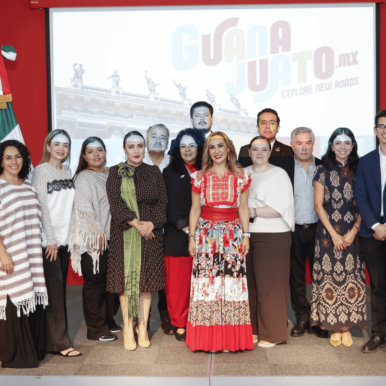 Grupo de personas en evento de promoción turística en Japón con bandera de Guanajuato.